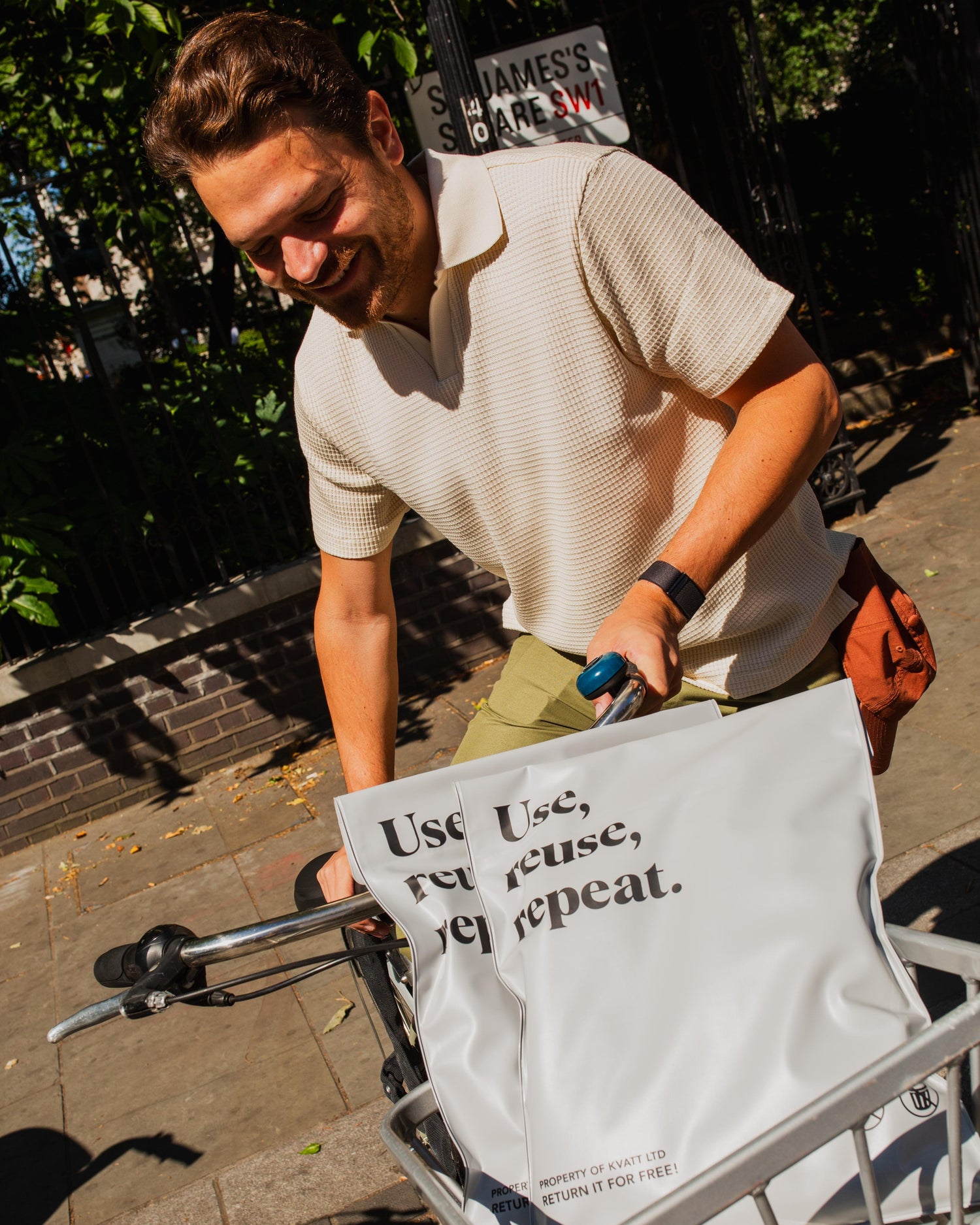Man pushing a cart with a reusable bag on a sidewalk